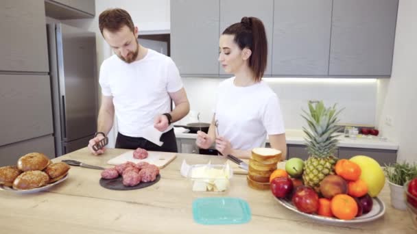 Pareja Praparing hamburguesas de carne en la cocina — Vídeo de stock