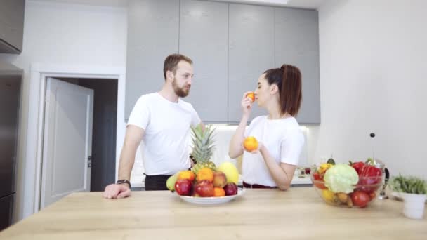 Giovane coppia allegra in cucina a discutere di frutta e verdura — Video Stock
