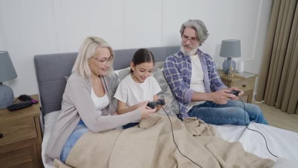 Ηλικιωμένο ζευγάρι που παίζει βιντεοπαιχνίδια μαζί με την εγγονή — Αρχείο Βίντεο