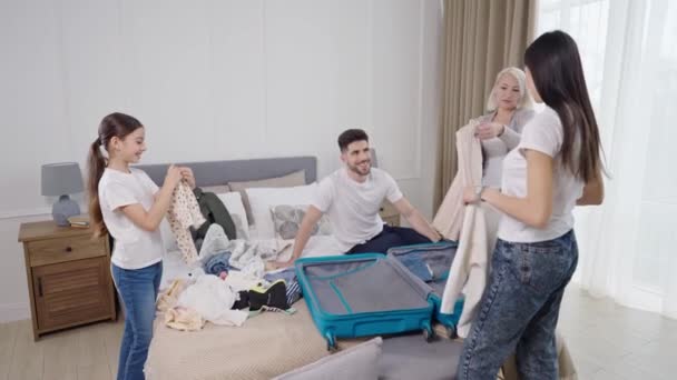 Grande famille emballant des vêtements dans une valise avant le vol d'avion, se préparant pour les vacances d'été — Video