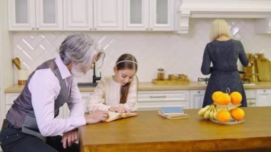 Güzel elbiseli sevimli küçük bir kız, anne ve babasını beklerken, dedeleriyle evde vakit geçiriyor.