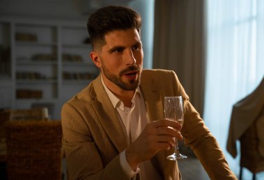 Çekici genç adam kadeh kaldırıyor ve kadeh kaldırıyor.