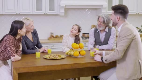 Generationenübergreifende glückliche Familie klappert Gläser mit Orangensaft, während sie gemeinsam Geburtstag des süßen kleinen Mädchens feiert — Stockvideo