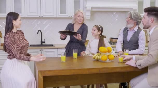 Мультигенна сім'я їсть домашнє печиво, святкуючи разом день народження милої маленької дівчинки — стокове відео