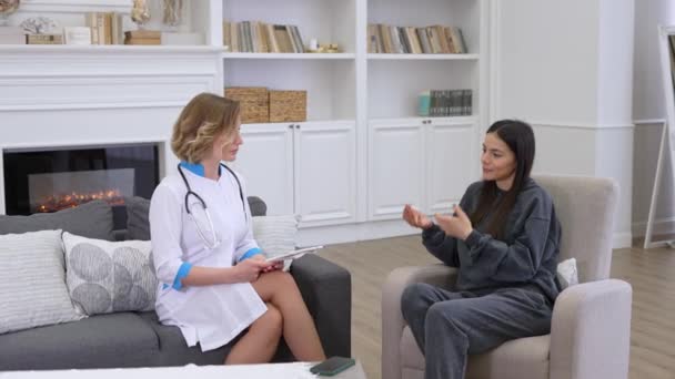 Dokter wanita dan pasien mengucapkan selamat tinggal satu sama lain setelah konsultasi medis di rumah — Stok Video