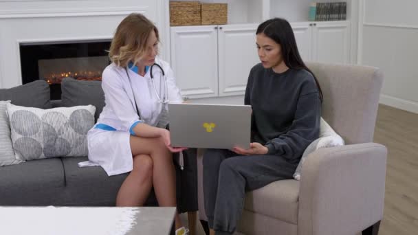 Doctora mostrando a la paciente los resultados de las pruebas médicas en la computadora portátil y prescribiendo medicamentos — Vídeo de stock