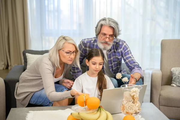 Petite fille mignonne et ses grands-parents aînés regardant l'écran d'ordinateur portable — Photo