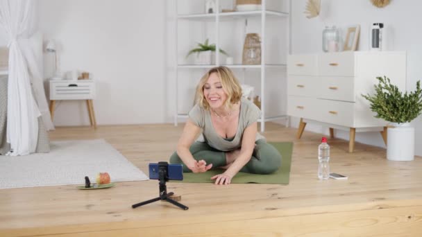 Instructeur de yoga professionnel saluant les adeptes tout en donnant des cours en ligne — Video