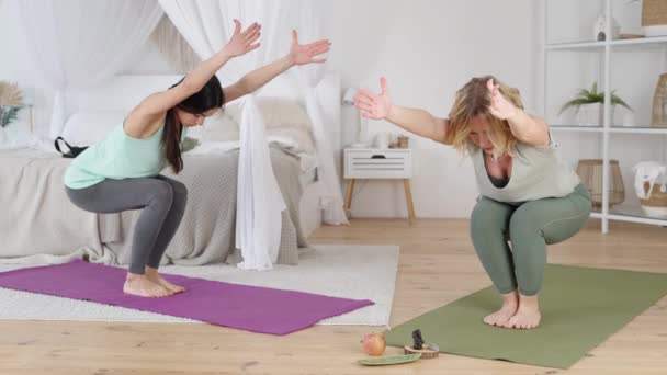 Instruktorka jógy a mladá žena provádějící cvičení s prodlouženými pažemi — Stock video