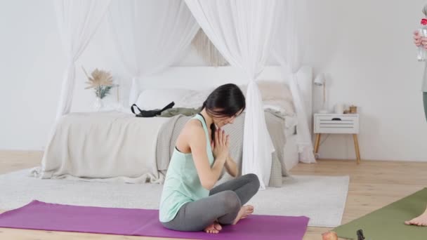 Istruttore dando acqua giovane donna dopo la pratica dello yoga — Video Stock