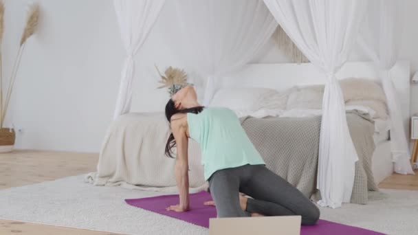 Woman practicing yoga with online trainer via video call — Vídeo de Stock