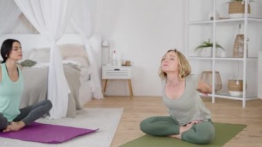 Yoga eğitmeni evde özel dersler sırasında streç egzersizleri gösteriyor.