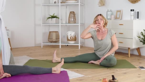 Professionele yoga trainer tonen stretching oefening aan jonge vrouw — Stockvideo