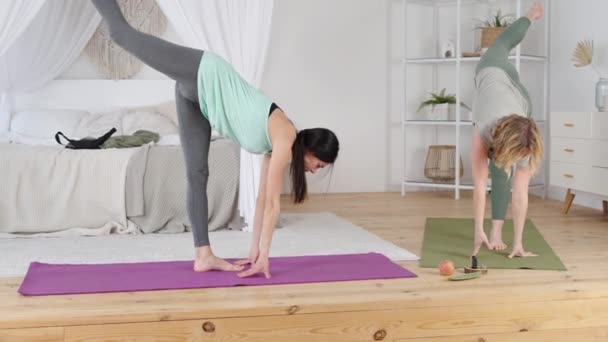 Vonzó nő és jógaoktató haladó szintű pozíciót gyakorolva — Stock videók