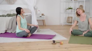 Profesyonel yoga eğitmeni ve boynunu uzatan genç bir bayan.