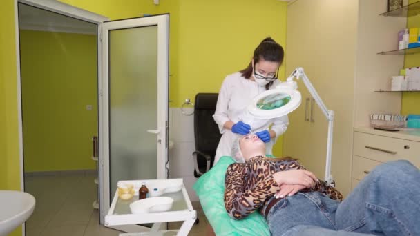 美容師は、ボツリヌス療法前に女性のクライアントの額の皮膚にマークを置く — ストック動画