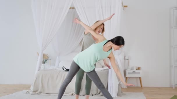 Yoga coach genezing vrouw uit te voeren halvemaanvormige linge asana — Stockvideo