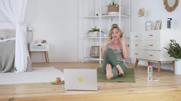 Entrenador de yoga profesional mirando a la computadora portátil mientras realiza clases en línea — Vídeos de Stock