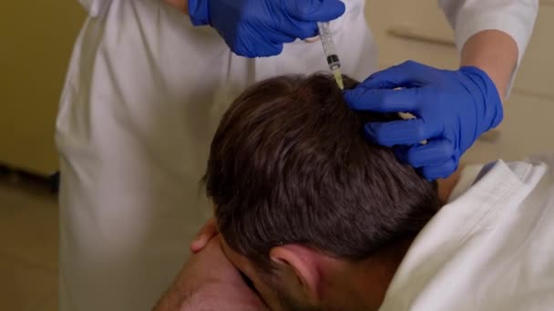 Arts injecteren van vitaminen in de hoofdhuid van mannelijke patiënt tijdens haar mesotherapie procedure — Stockvideo