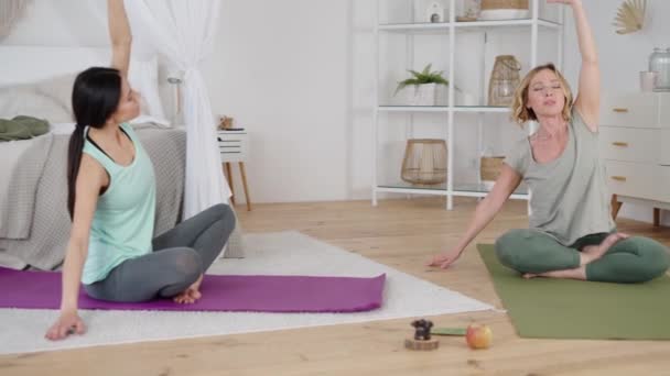 Mooie ontspannen dames die thuis yoga uitvoeren — Stockvideo