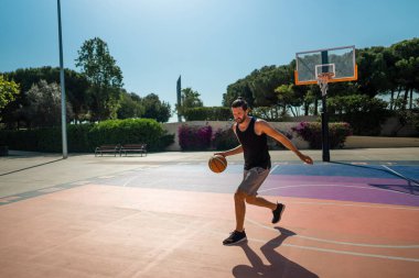 Basketbolcu kendini basketbol sahasında topla eğitiyor.