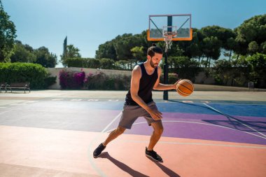 Basketbolcu kendini basketbol sahasında topla eğitiyor.