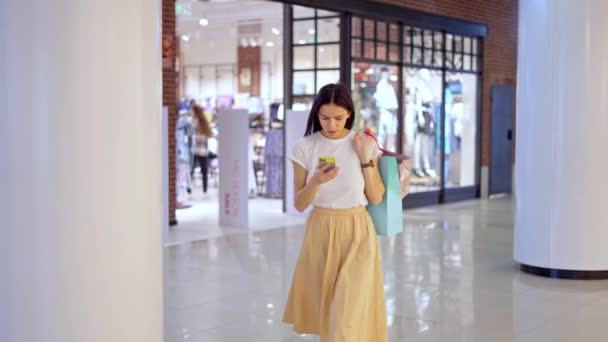Piękna kobieta korzystająca z nawigacji online podczas próby znalezienia sklepu w centrum handlowym — Wideo stockowe