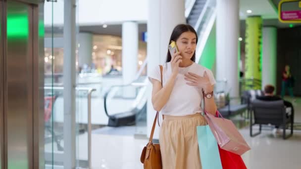 Жінка дзвонить подрузі і розповідає про покупки в торговому центрі — стокове відео