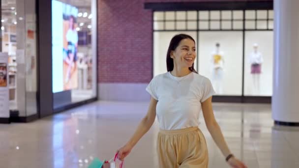 Başarılı bir alışveriş gününden sonra heyecanla atlayan aşırı neşeli bir kadın. — Stok video