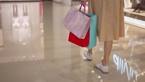 Vacker kvinna som bär shoppingväskor i kommersiella centrum — Stockvideo