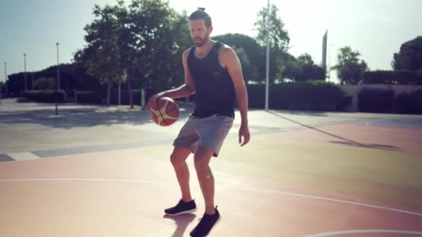 Goteando. Atleta jugador de baloncesto sostiene la pelota y lanza la pelota en el ring — Vídeos de Stock