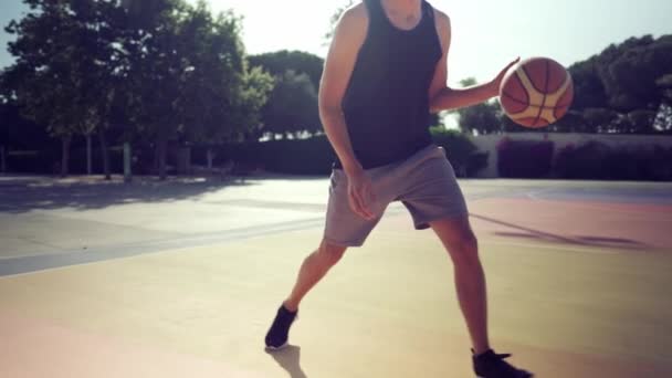 Joueur de basket-ball s'entraîne sur un terrain de basket avec une balle — Video