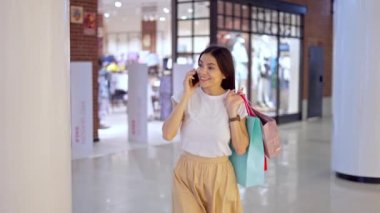 Alışveriş günü arkadaşlarıyla cep telefonundan konuşan bir kadın.