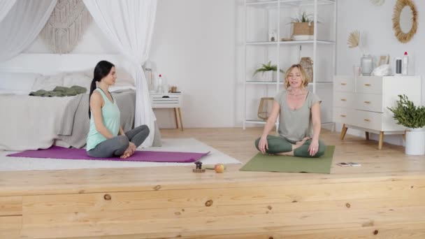 Yoga instructeur tonen jonge vrouw ademhaling oefening — Stockvideo