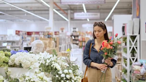 Jonge vrouwelijke klant het kopen van kunstmatige bloemen voor home decor — Stockvideo