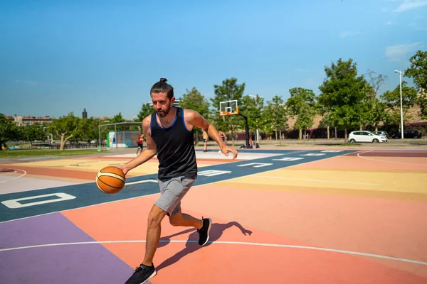 Ein männlicher Basketballspieler läuft mit einem Ball auf einem Basketballfeld — Stockfoto
