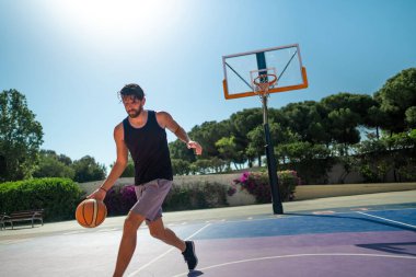 Basketbolcu kendini basketbol sahasında topla eğitiyor.