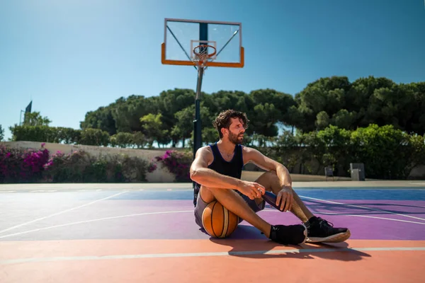Tired handsome Man basketball player sits