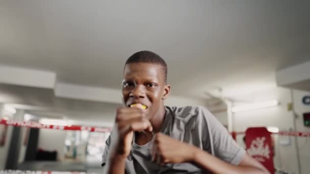 Petinju muda afrika yang termotivasi melemparkan pukulan ke arah kamera selama pelatihan tinju di olahraga — Stok Video