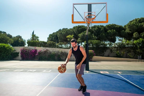 Basketbolcu elinde topla basketbol sahasında koşar.