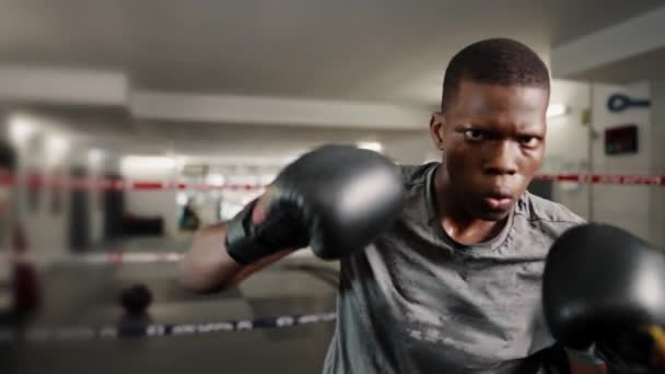 Starkt motiverad kickboxare som bär muntuggummi sköld stansning mot kameran med handskar nävar — Stockvideo