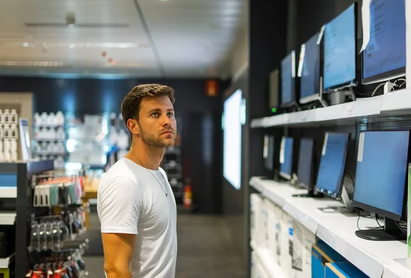 Hombre pensativo elegir el ordenador en la tienda — Foto de Stock