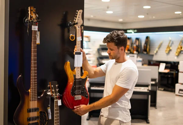 Guitarrista compra de instrumento musical en la tienda — Foto de Stock