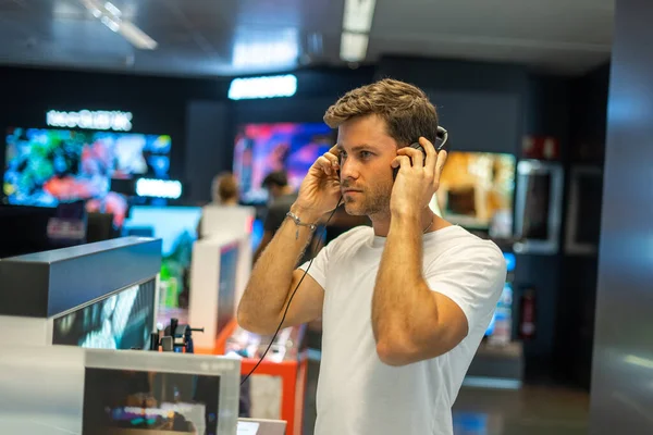 Hombre probando auriculares en la tienda — Foto de Stock