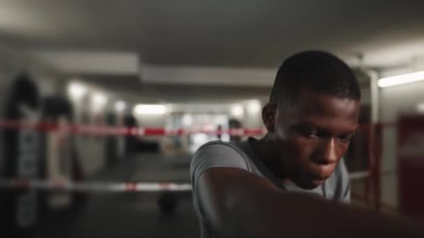 Ung säker afrikansk man boxare utbildning under boxning klass i gym — Stockvideo