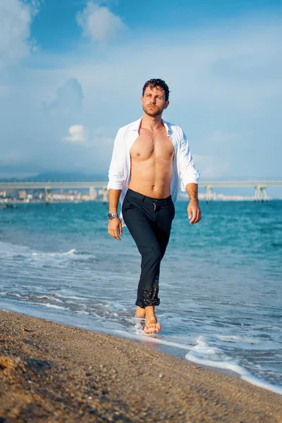 Hombre caminando en la playa al atardecer —  Fotos de Stock