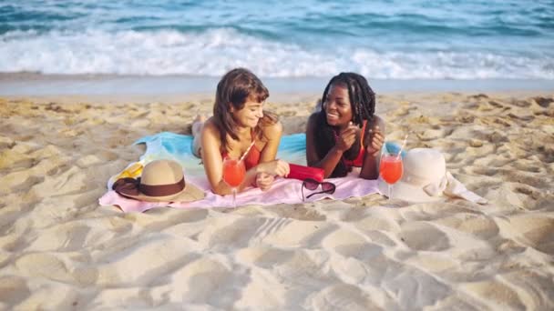 Дві студентки проводять літні канікули на пляжі — стокове відео
