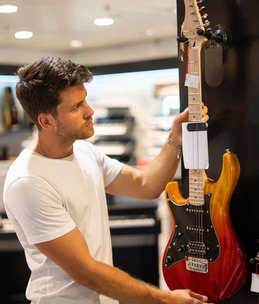 Cliente elegir la guitarra en la tienda — Foto de Stock