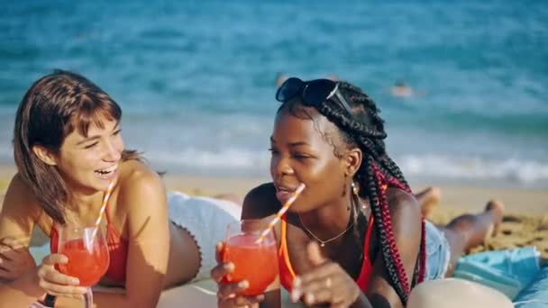 Beste vrienden liggend op zandstrand met cocktails — Stockvideo