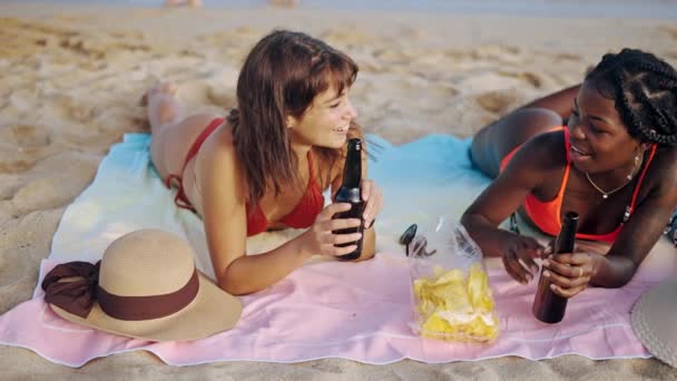 Dos hermosas diferentes razas chicas tomando el sol en la playa — Vídeos de Stock